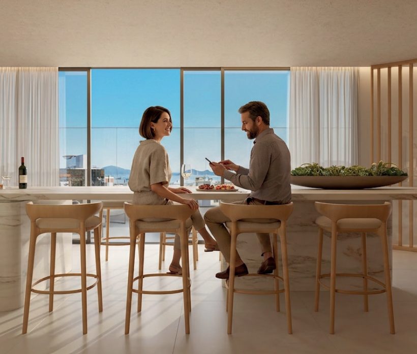 Casal na cozinha integrada de um apartamento do Joá